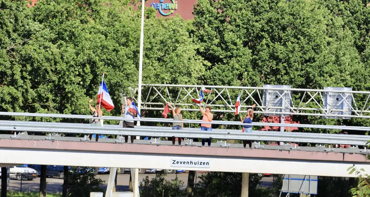 Verontrustende burgers staan met omgekeerde vlaggen zwaaien naar verkeer op A1 - Foto 1