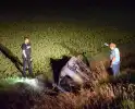 Auto op zijn kop in sloot naast talud