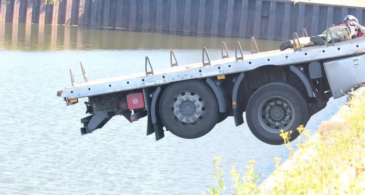 Vrachtwagen hangt gevaarlijk over de waterkant