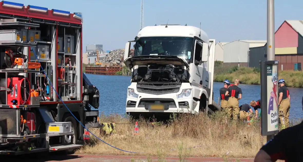 Vrachtwagen hangt gevaarlijk over de waterkant - Foto 4