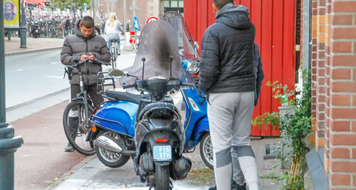 Omstanders blussen brandende scooter - Foto 1