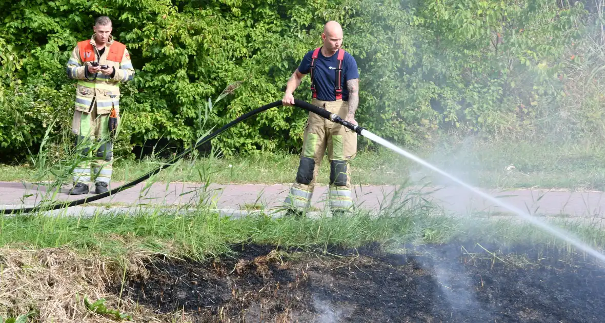Man helpt brand blussen met emmers water - Foto 3