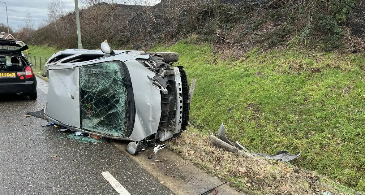 Auto op zijn kant bij eenzijdige aanrijding - Foto 1