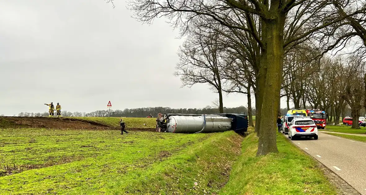 Vrachtwagen belandt op zijn kant naast de weg