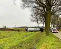 Vrachtwagen belandt op zijn kant naast de weg