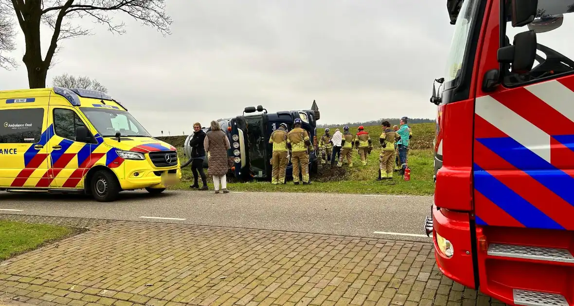 Vrachtwagen belandt op zijn kant naast de weg - Foto 2