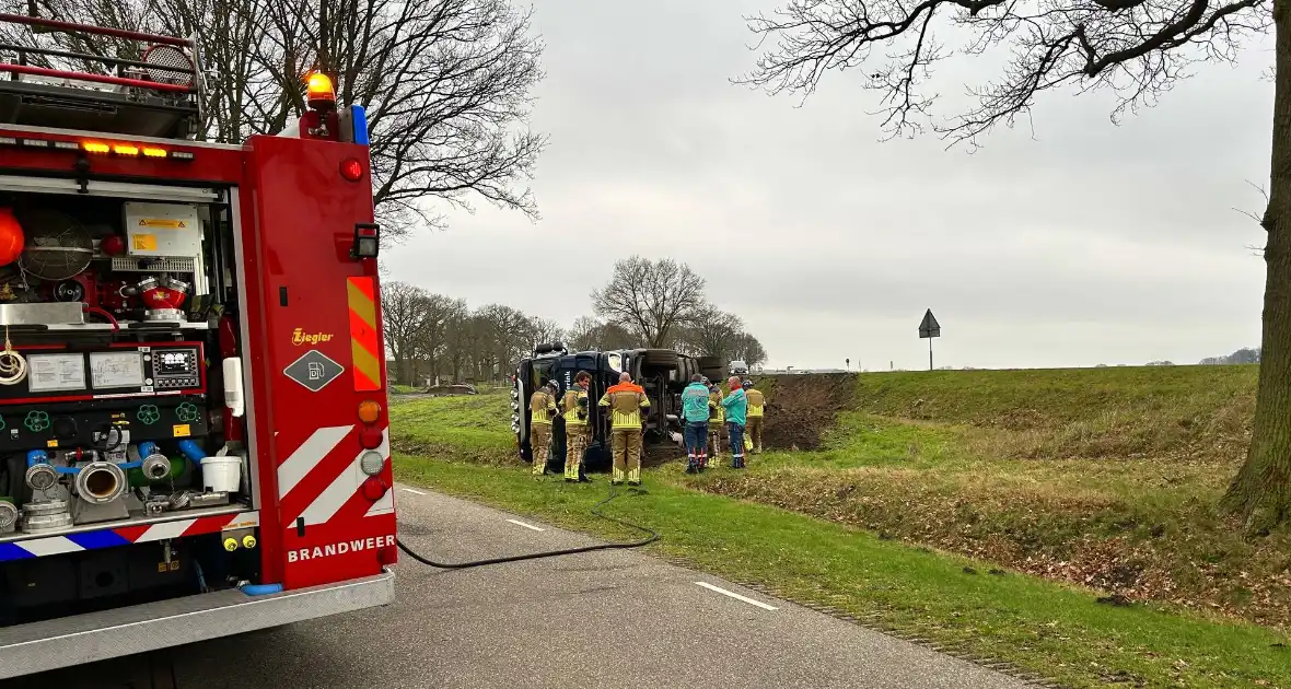 Vrachtwagen belandt op zijn kant naast de weg - Foto 3