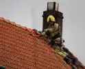 Dak beschadigd door brand, brandweerman onwel tijdens inzet