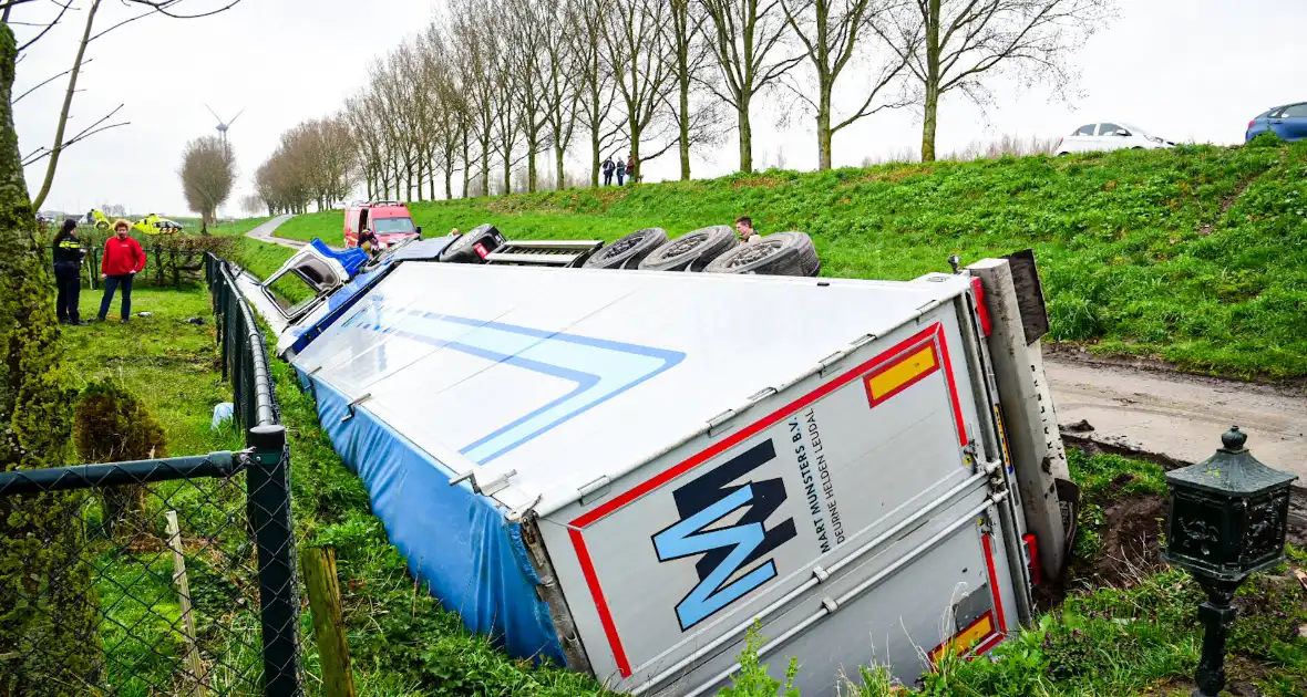 Chauffeur bekneld nadat vrachtwagen in slootkantelt - Foto 1