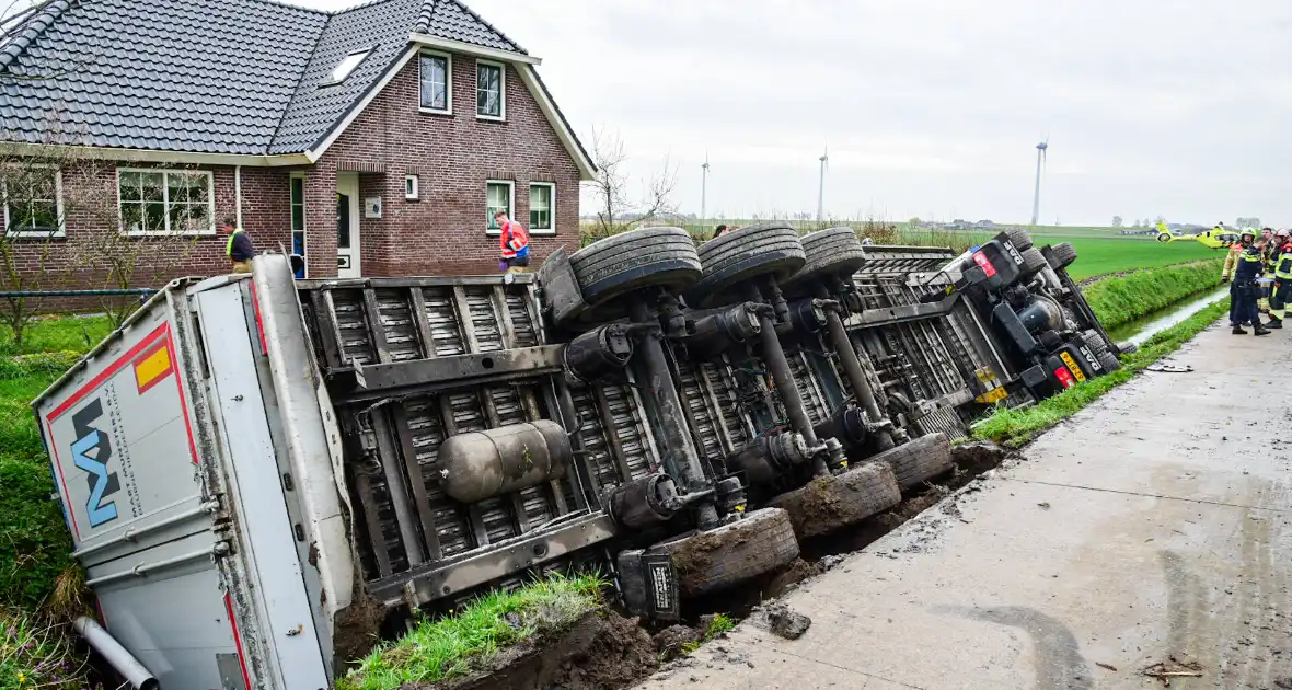 Chauffeur bekneld nadat vrachtwagen in slootkantelt - Foto 5