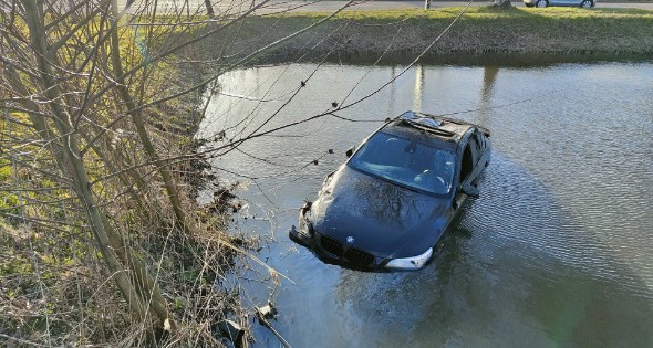 Automobilist vliegt uit bocht, ramt boom en belandt in water