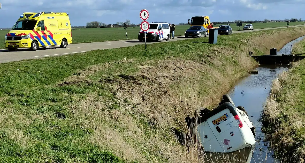 Bestelbus belandt in de sloot na botsing met auto