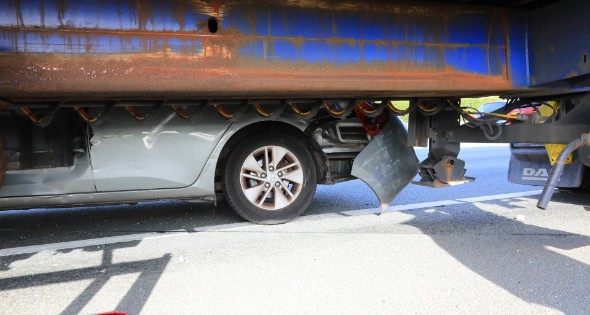 Auto vast onder vrachtwagen oplegger