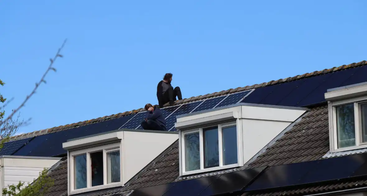 Twee personen op dak van woning - Foto 1