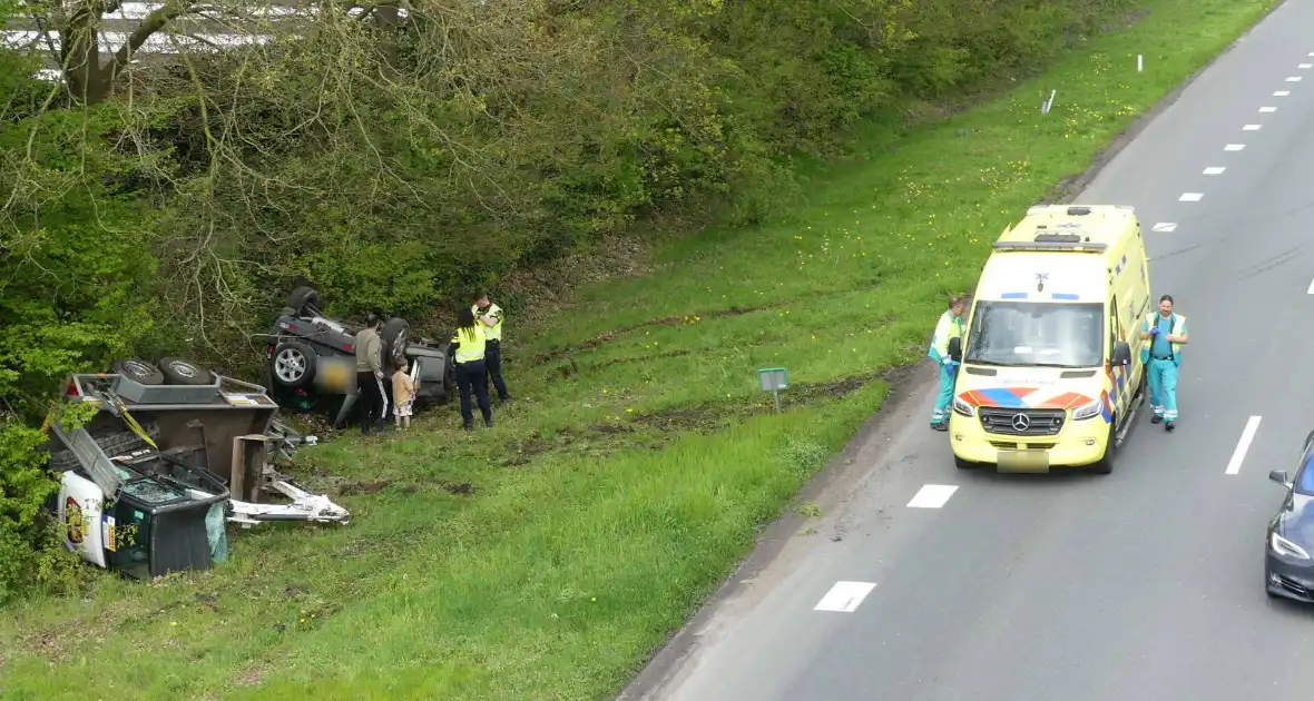 Auto en aanhanger met graafmachine over de kop - Foto 1