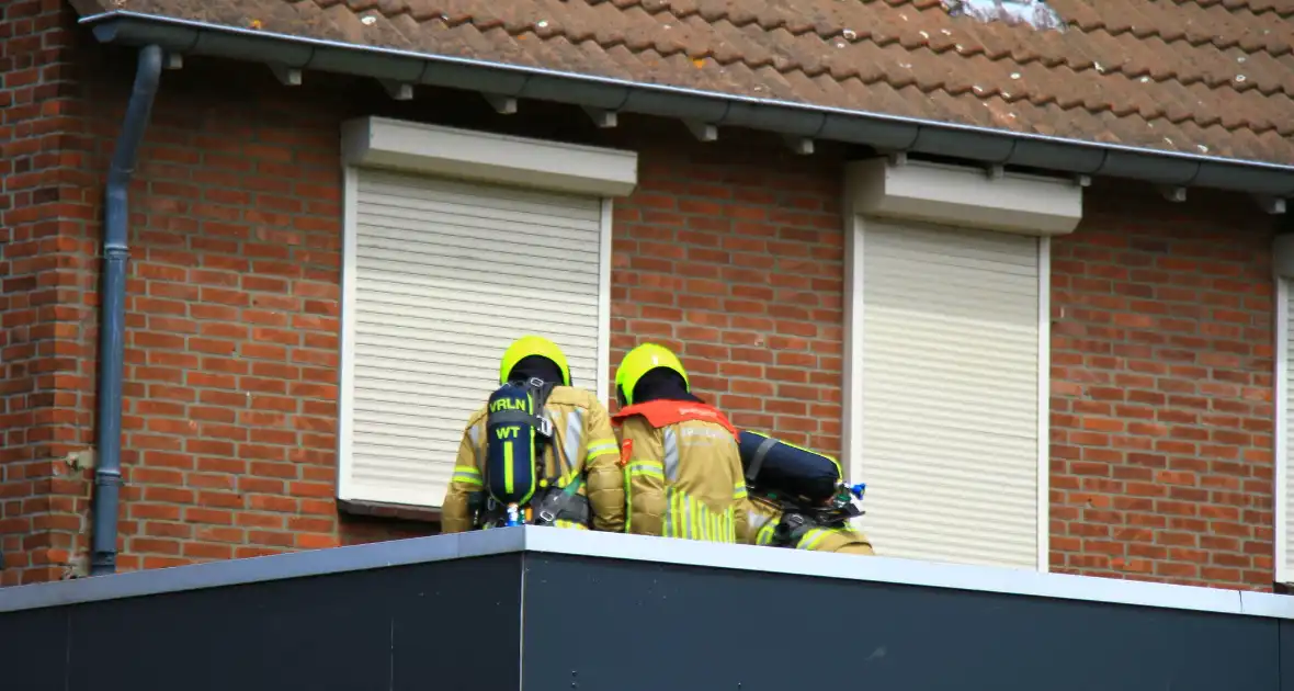 Brandweer blust brand op een dak van woning - Foto 1