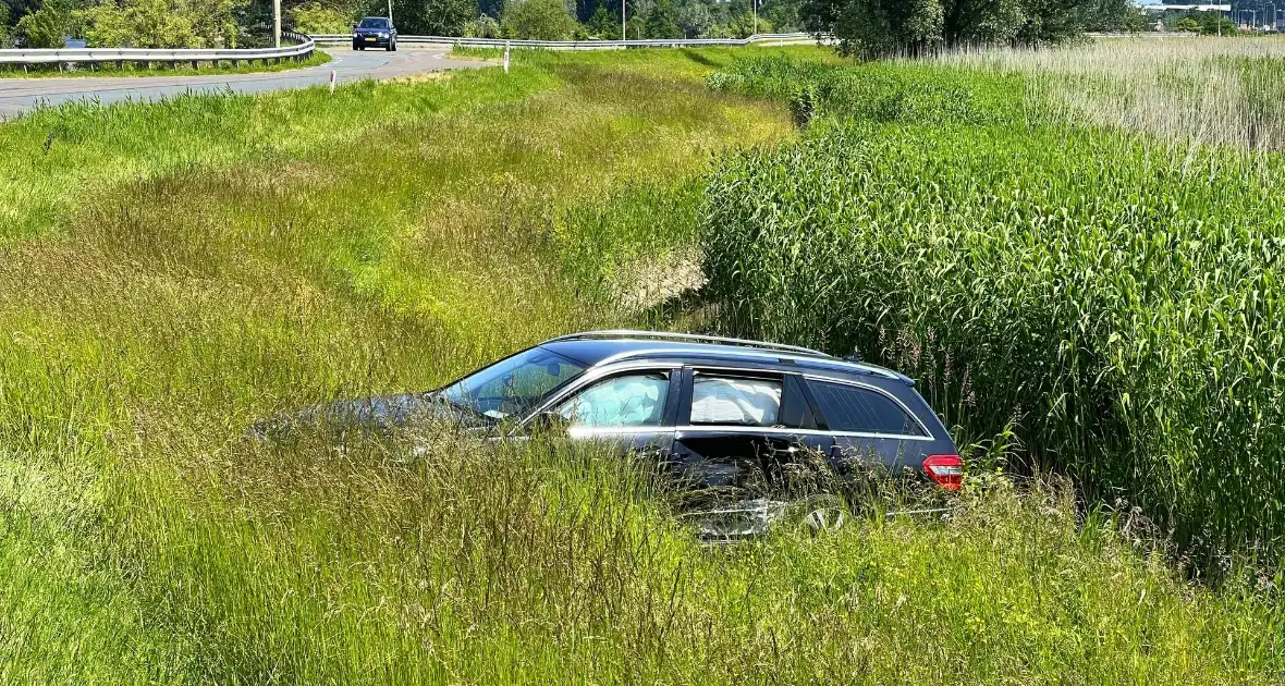 Auto raakt van dijk na heftige botsing - Foto 1