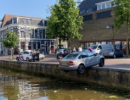Auto blijft op randje van kade hangen boven gracht