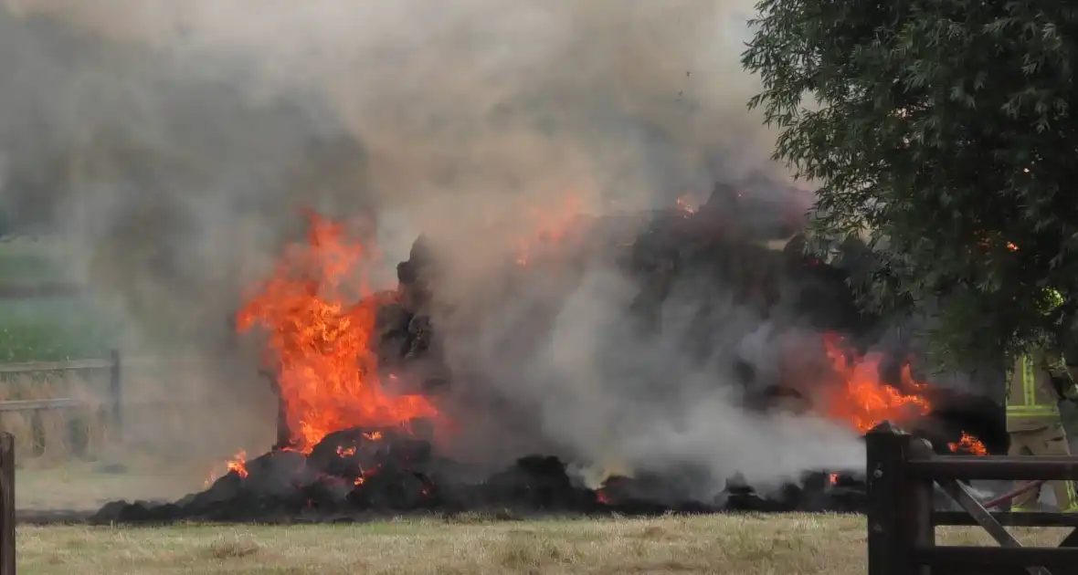 Trailer geladen met hooibalen uitgebrand in weiland