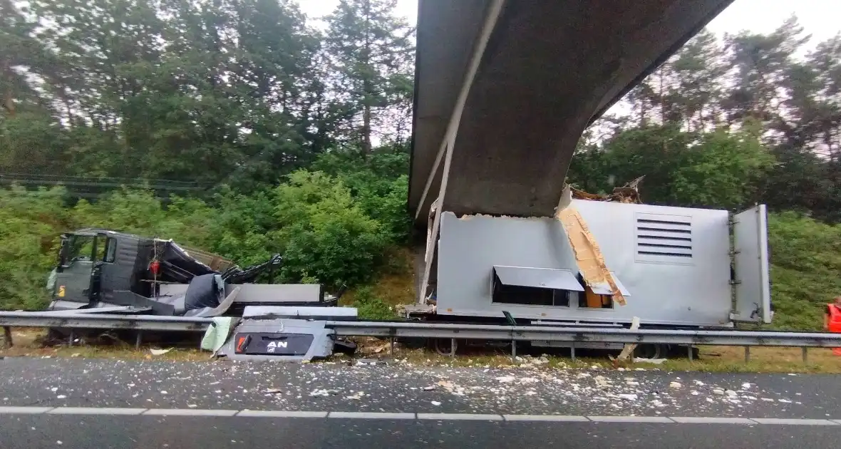 Enorme schade nadat vrachtwagen tegen viaduct rijdt - Foto 1