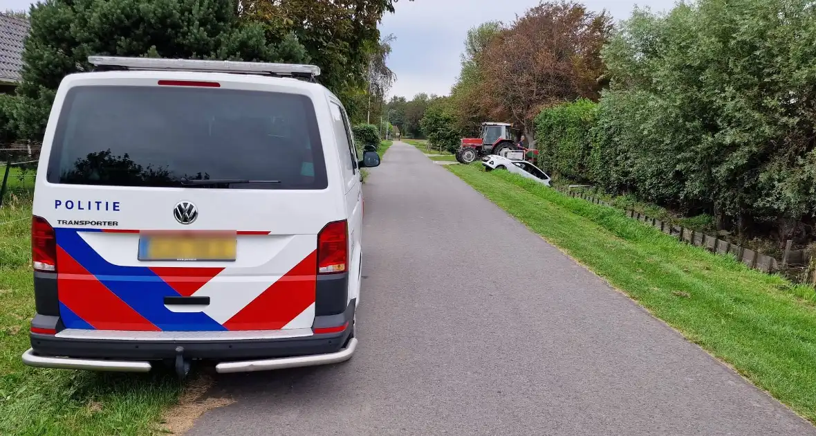 Auto rijdt achteruit de sloot in