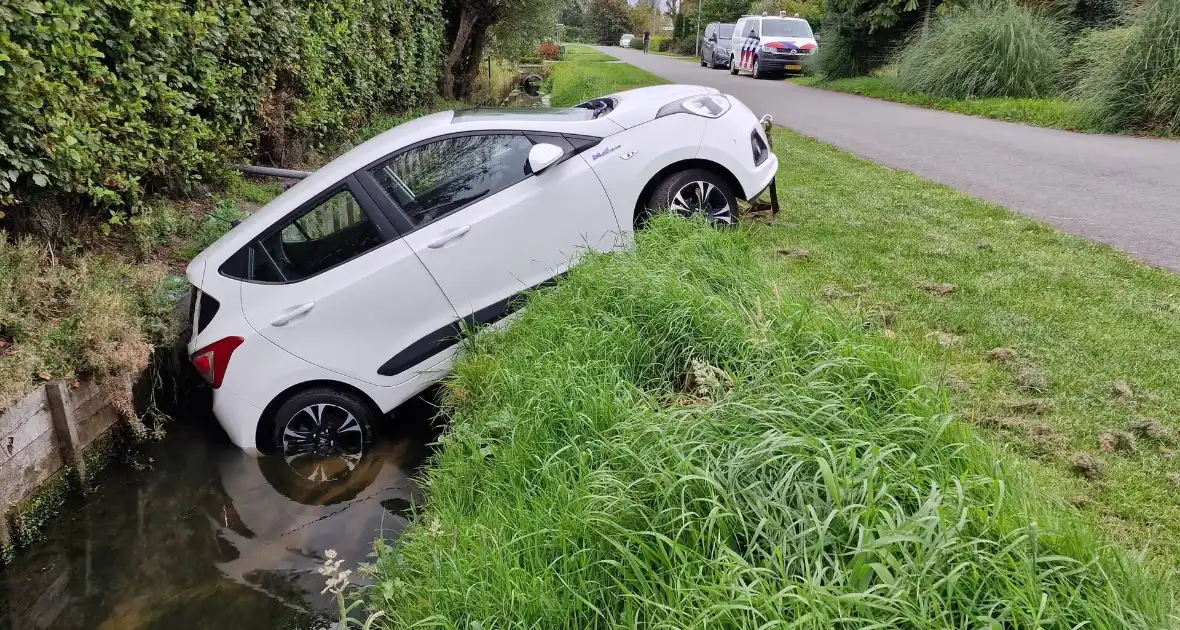 Auto rijdt achteruit de sloot in - Foto 1