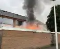 Uitslaande brand in schuur slaat over naar woning