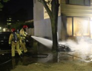 Scooter in brand tegen woning