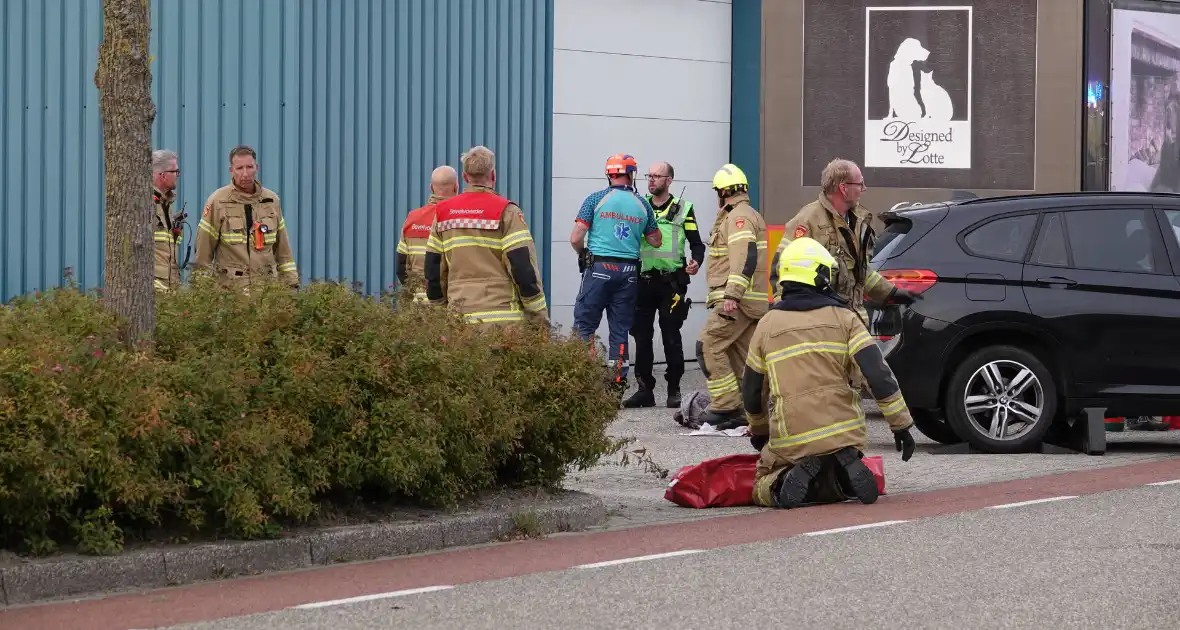 Scooterrijder bekneld onder auto - Foto 3