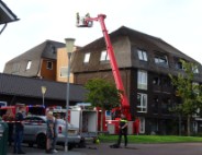 Brand op dak van appartementencomplex met rietendak