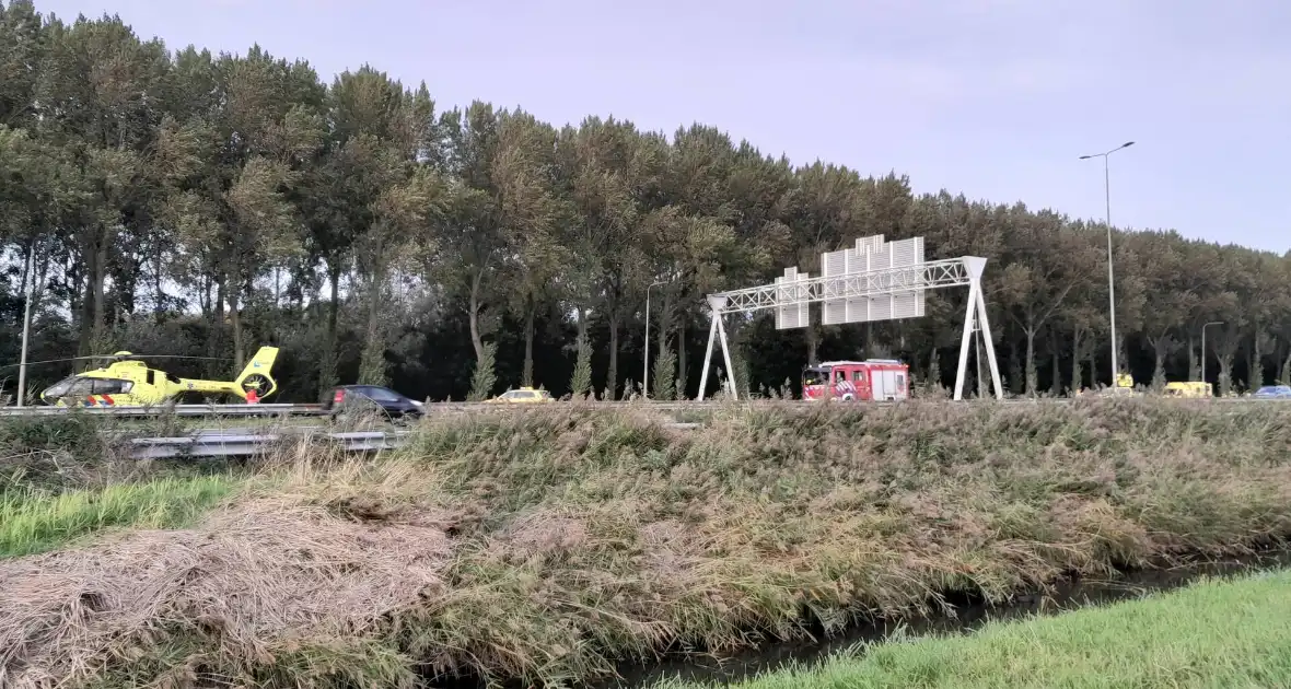 Traumahelikopter landt op snelweg nadat auto tegen boom klapt, twee gewonden - Foto 1