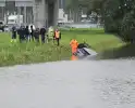 Auto raakt te water naast snelweg