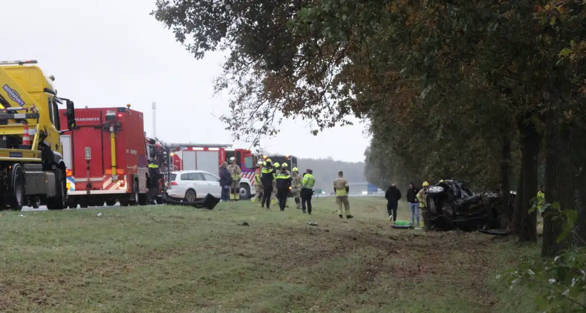 Auto zwaar beschadigd na botsing tegen boom langs snelweg