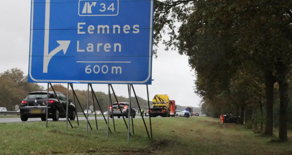Auto zwaar beschadigd na botsing tegen boom langs snelweg - Foto 11