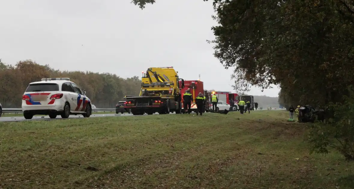 Auto zwaar beschadigd na botsing tegen boom langs snelweg - Foto 2