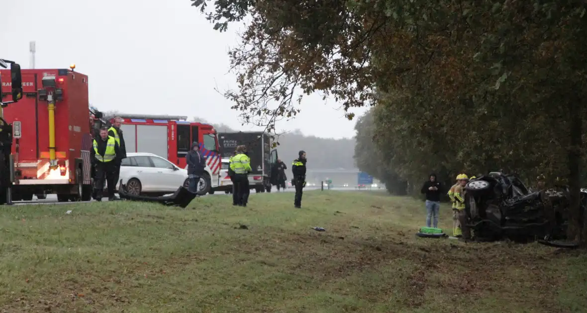 Auto zwaar beschadigd na botsing tegen boom langs snelweg - Foto 3