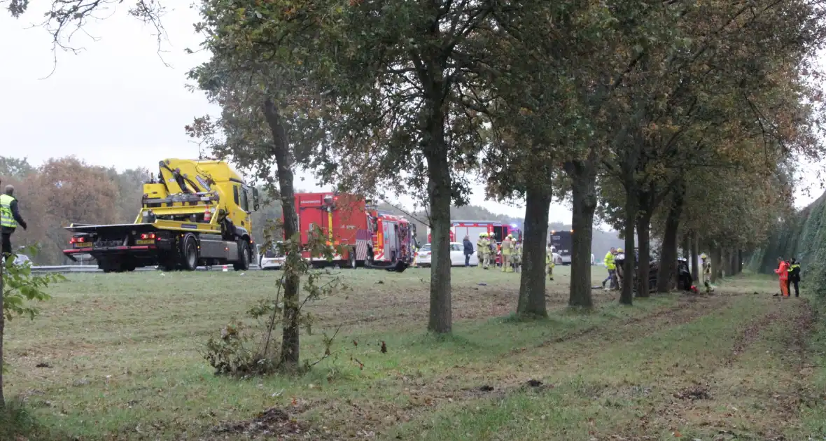 Auto zwaar beschadigd na botsing tegen boom langs snelweg - Foto 4