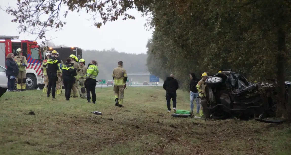 Auto zwaar beschadigd na botsing tegen boom langs snelweg - Foto 6