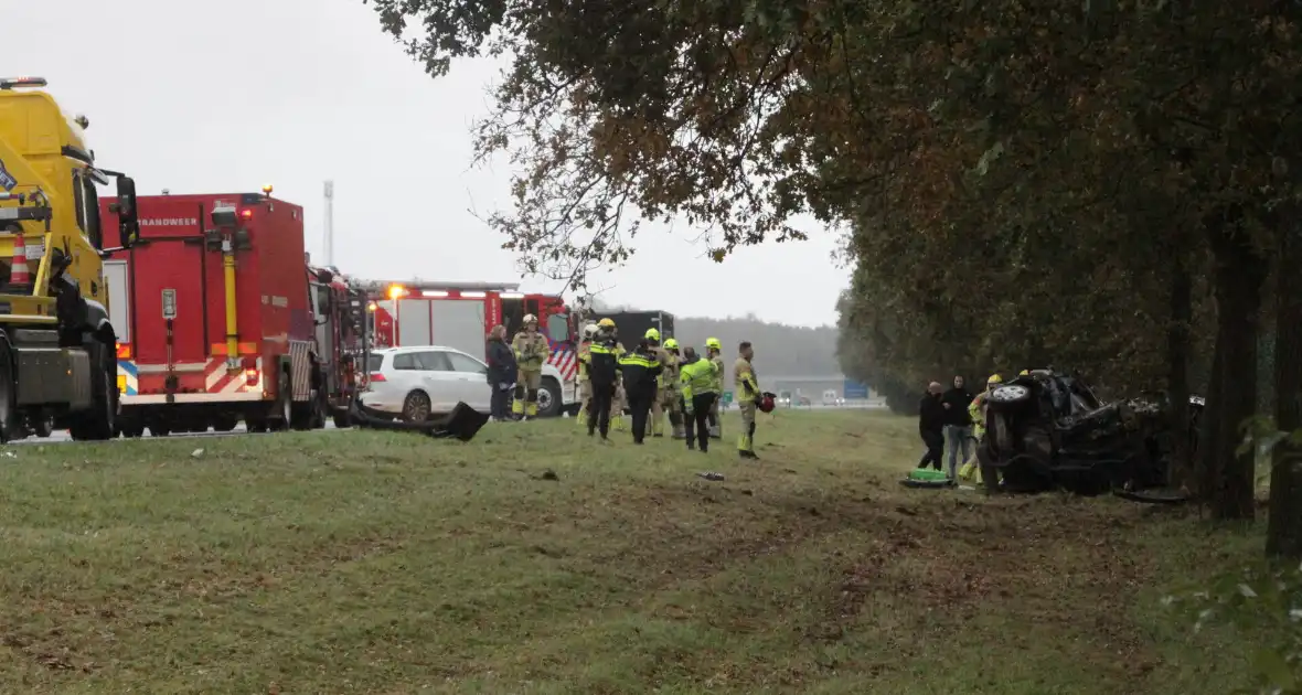Auto zwaar beschadigd na botsing tegen boom langs snelweg - Foto 8