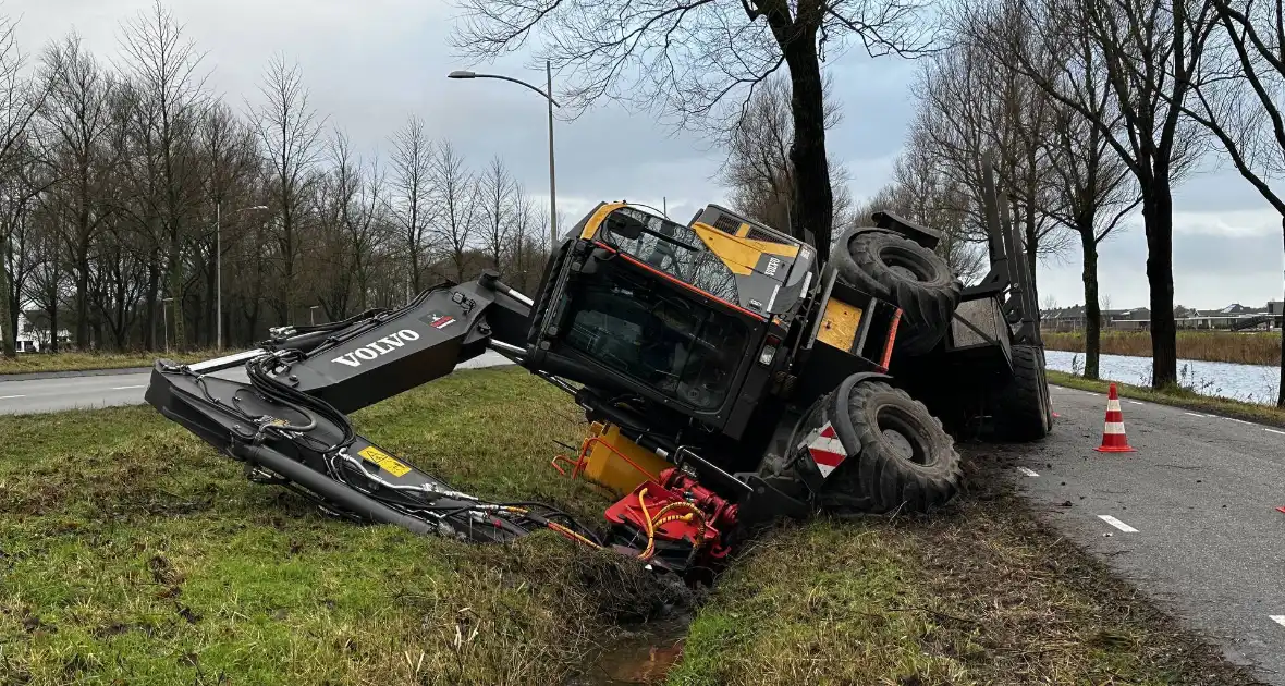 Graafmachine kantelt en komt in sloot terecht - Foto 1