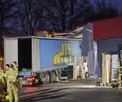 Truck met oplegger rijdt bedrijfspand binnen