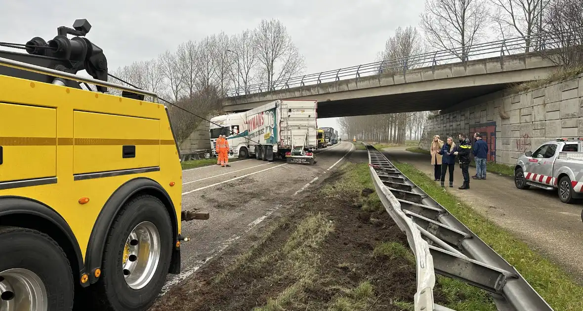 Vrachtwagen schaart en botst tegen viaduct