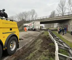 Vrachtwagen schaart en botst tegen viaduct