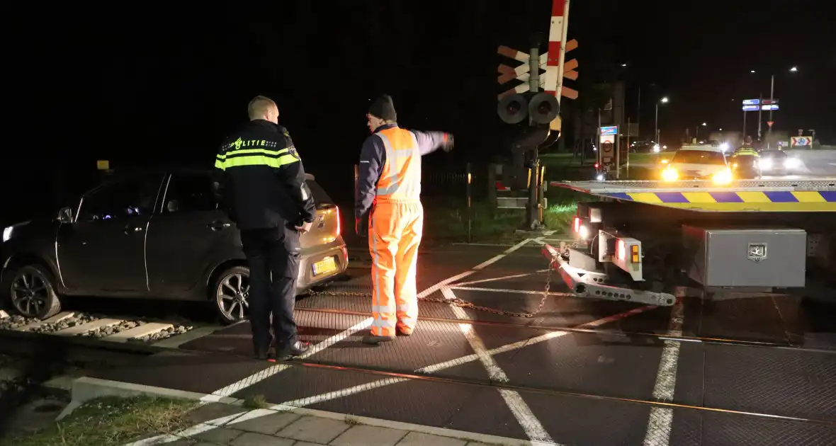 Persoon laat auto op spoor achter