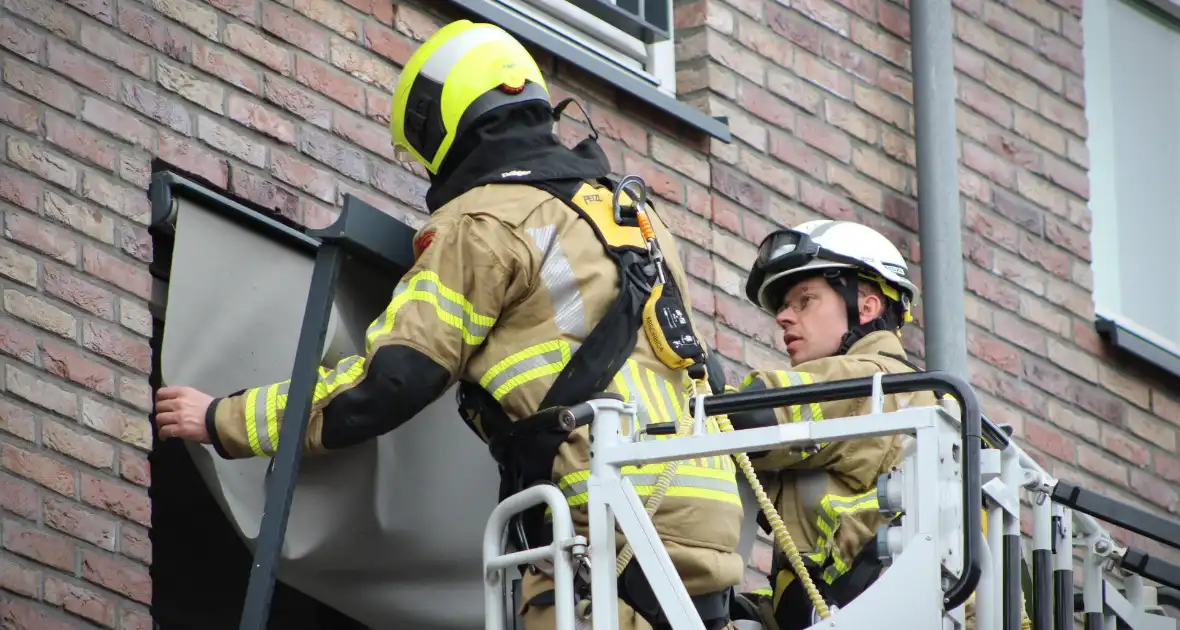 Brandweer zet loshangende zonnescherm vast - Foto 1