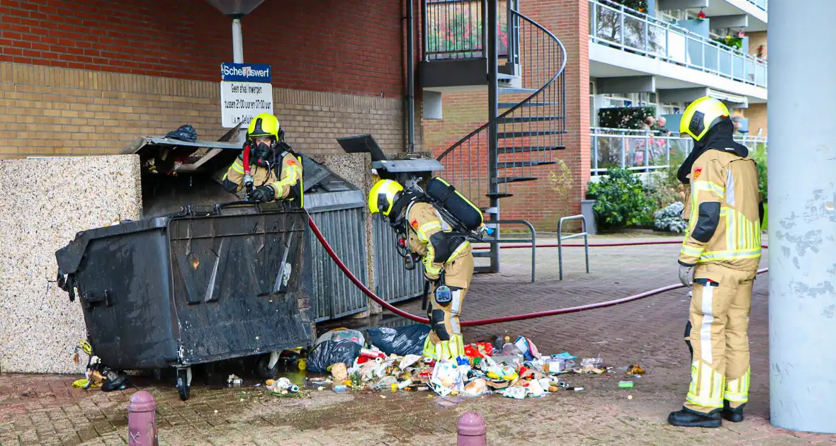 Containers onder flatgebouw in brand - Foto 4