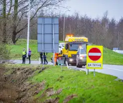 Auto raakt van de weg in bocht van afrit