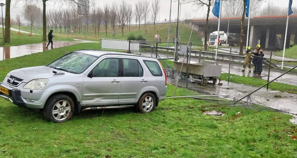Automobilist rijdt door hekwerk van tankstation