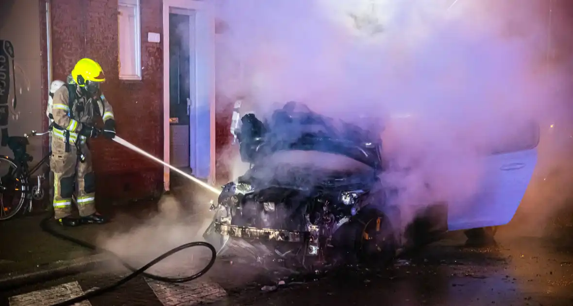 Brandweer blust in brand staande auto - Foto 1