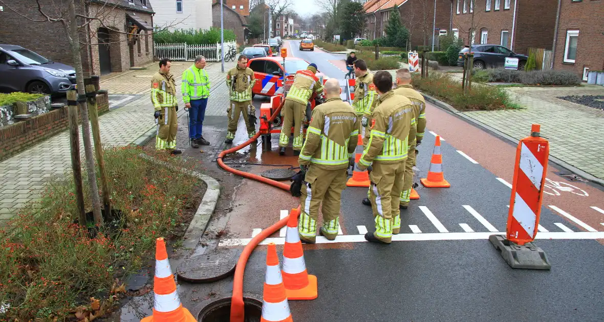 Straat onder water na overstroming riool